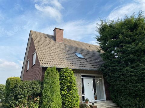 Gereinigtes Satteldach eines Wohnhauses mit Hecke davor