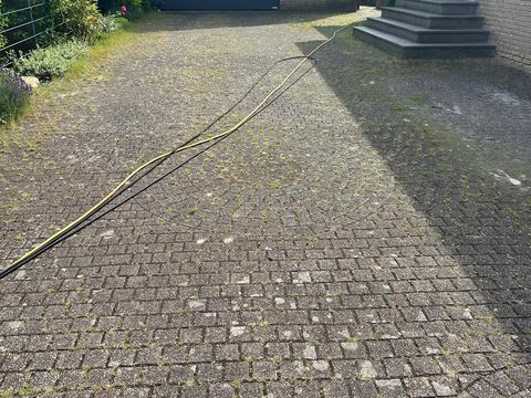 Gereinigtes Pflaster in geschwungenem Verlegemuster vor einer Garage