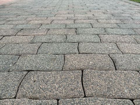 Gereinigter Terrassenweg aus grauen Platten neben Kiesbeet